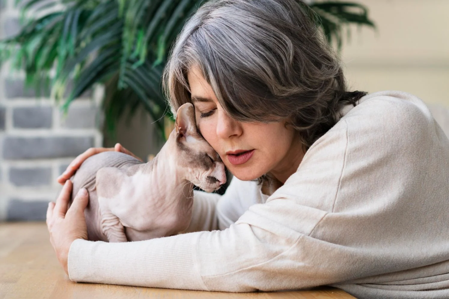 Woman showing affection to a cat, illustrating the Science Behind Animal-Assisted Therapy and the healing bond between humans and animals.
